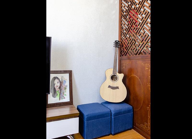 Vách ngăn gỗ giúp ngăn cách không gian phòng khách và bàn thờ. Nữ diễn viên không biết chơi guitar nhưng chuẩn bị sẵn một chiếc đàn để bạn bè đến chơi. 
