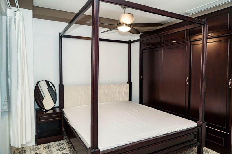 Một phòng ngủ khác mang phong cách nhiệt đới với nội thất bằng gỗ, nền lót gạch bông hoa văn xưa.
